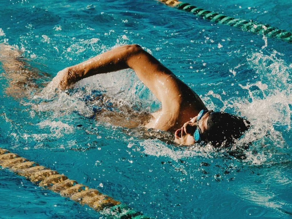 Olimpik havuzda yüzen bir yüzme kursu öğrencisi
